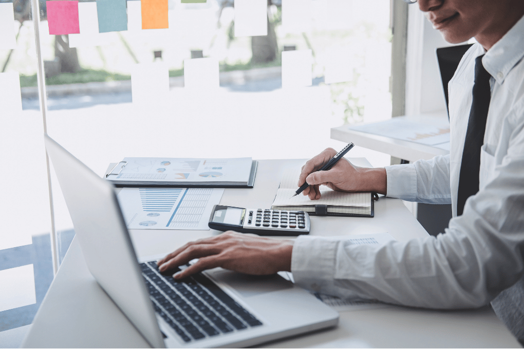 Alberta business owner reviewing financial reports and corporate year-end tax planning calculations